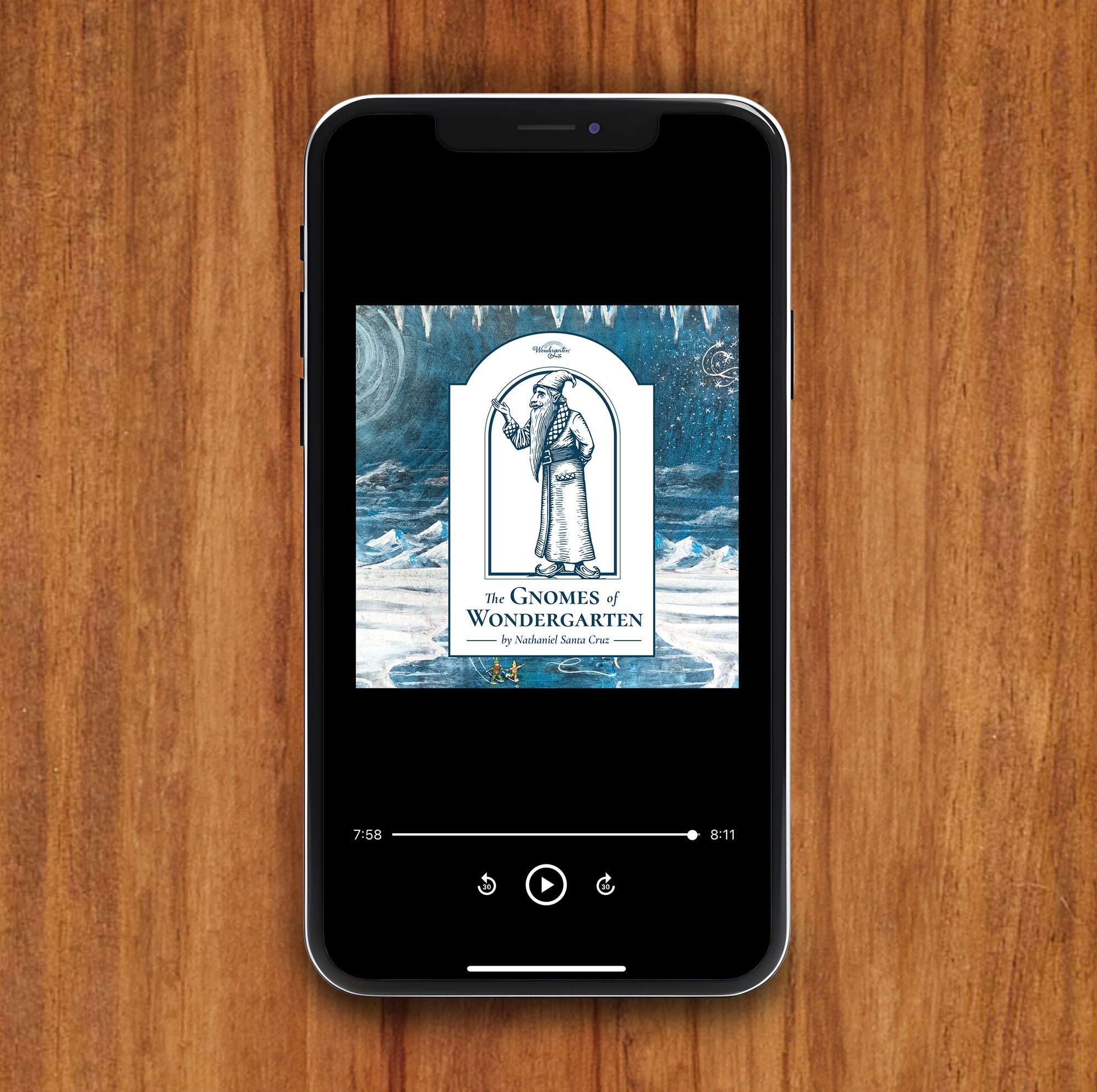 Phone displaying an audiobook cover of 'The Gnomes of Wondergarden' on a wooden surface
