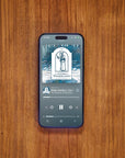 Phone displaying Apple Podcast The Gnomes of Wondergarten on wooden table